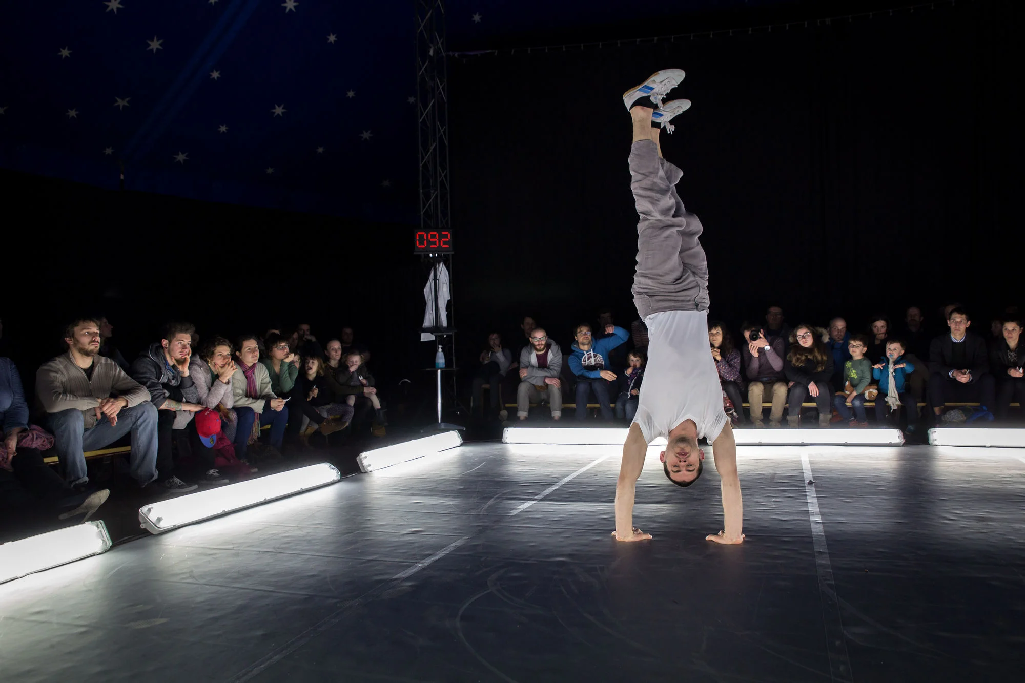 Adrien Taffanel en équilibre dans carré de néons - Spectacle PATIENT cirque contemporain
